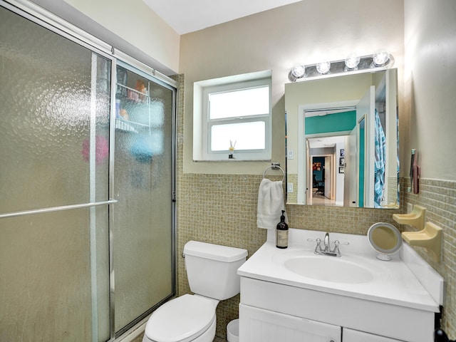 bathroom with a shower with door, tile walls, and toilet