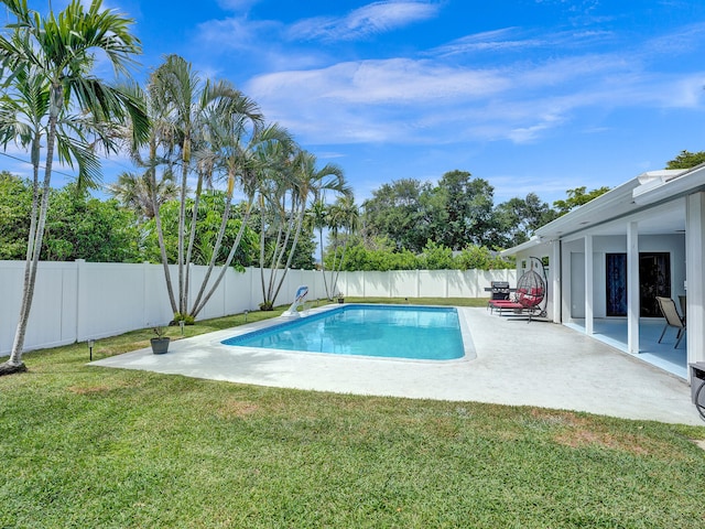 view of pool with a patio area and a lawn