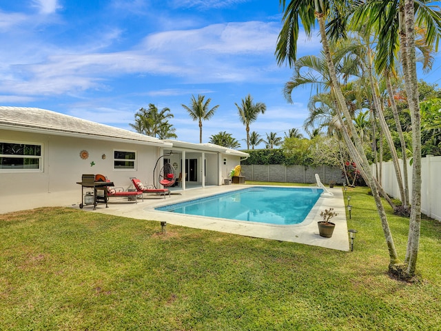 view of pool with a lawn, a patio, and grilling area