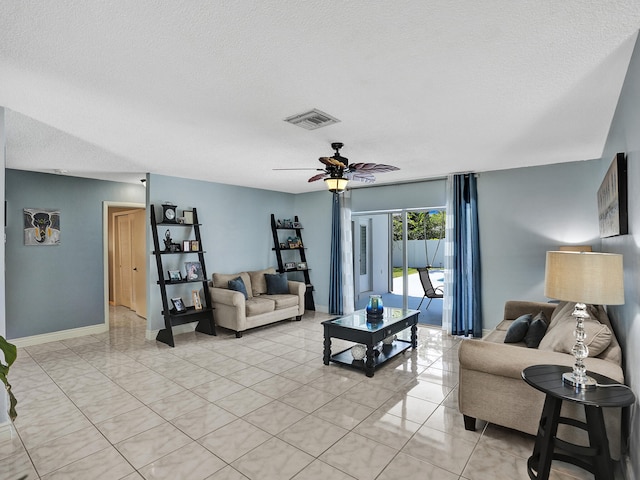 tiled living room with ceiling fan and a textured ceiling