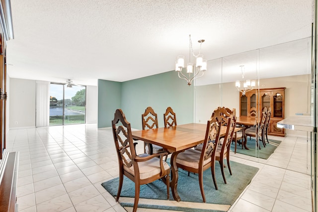 tiled dining room featuring ceiling fan with notable chandelier and a textured ceiling