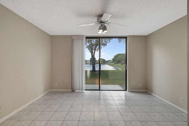 unfurnished room with a water view, floor to ceiling windows, ceiling fan, light tile flooring, and a textured ceiling