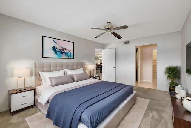 bedroom featuring connected bathroom, light carpet, and ceiling fan