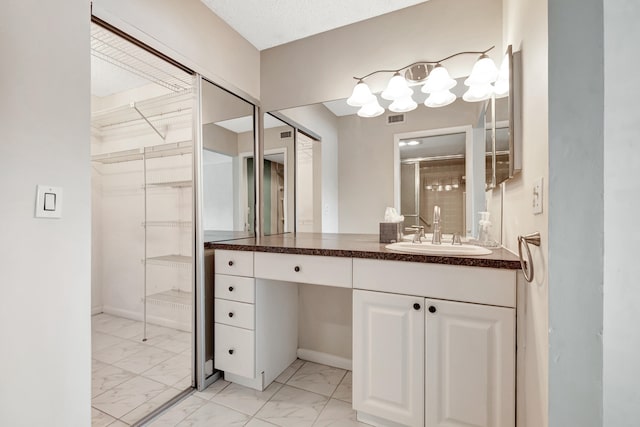 bathroom featuring tile floors, vanity, and a textured ceiling