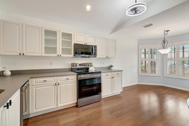 kitchen with hanging light fixtures, stainless steel appliances, lofted ceiling, white cabinets, and light wood-type flooring