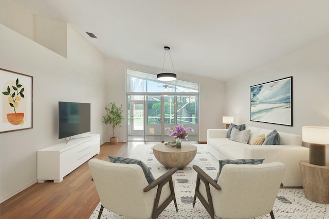 living room featuring light hardwood / wood-style flooring and lofted ceiling