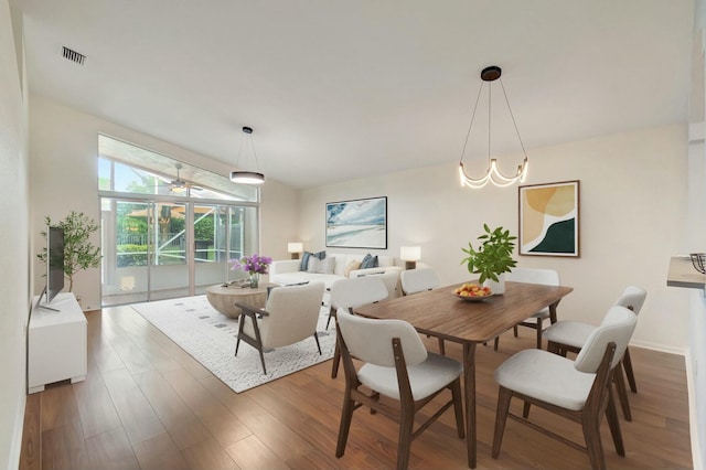 dining space with dark wood-type flooring and vaulted ceiling