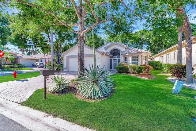 view of front of home with a front yard and a garage