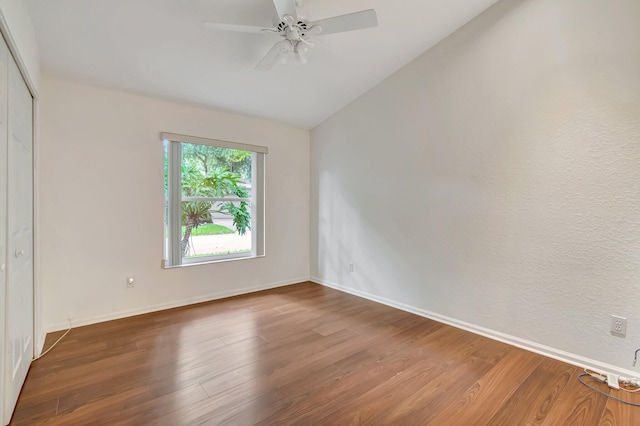 spare room featuring wood-type flooring, vaulted ceiling, and ceiling fan