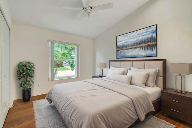 bedroom featuring lofted ceiling, a closet, ceiling fan, and dark wood-type flooring