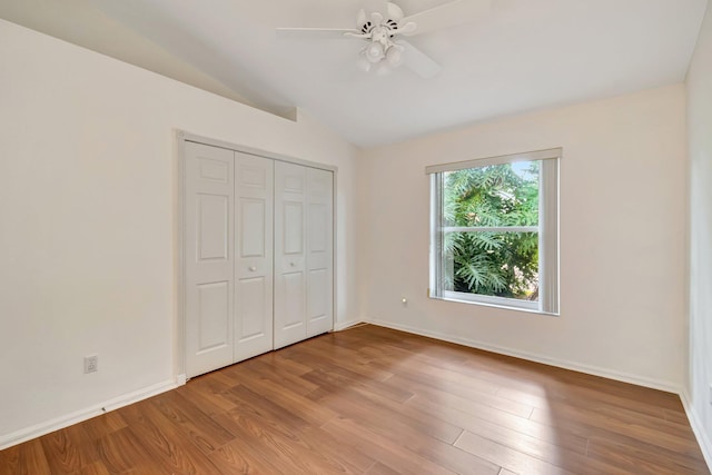 unfurnished bedroom featuring a closet, ceiling fan, light hardwood / wood-style flooring, and lofted ceiling