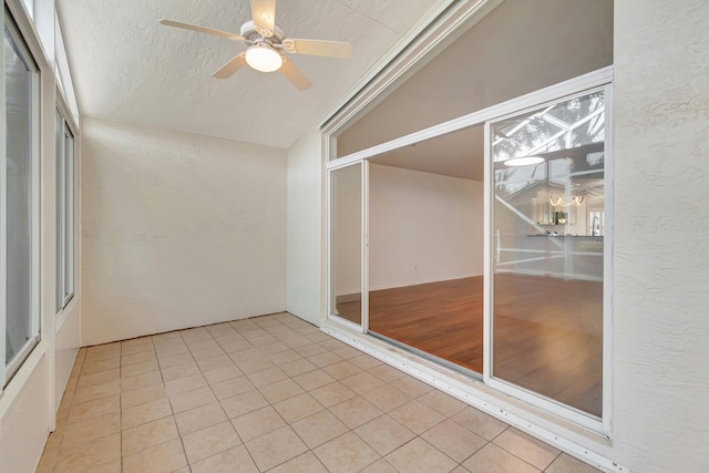 unfurnished sunroom featuring ceiling fan