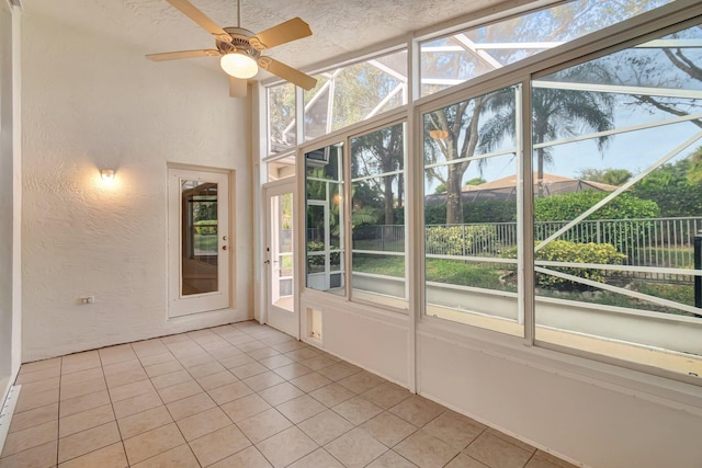 unfurnished sunroom featuring ceiling fan