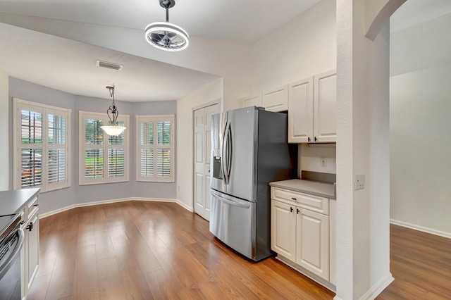 kitchen with white cabinets, stainless steel appliances, light hardwood / wood-style flooring, and hanging light fixtures