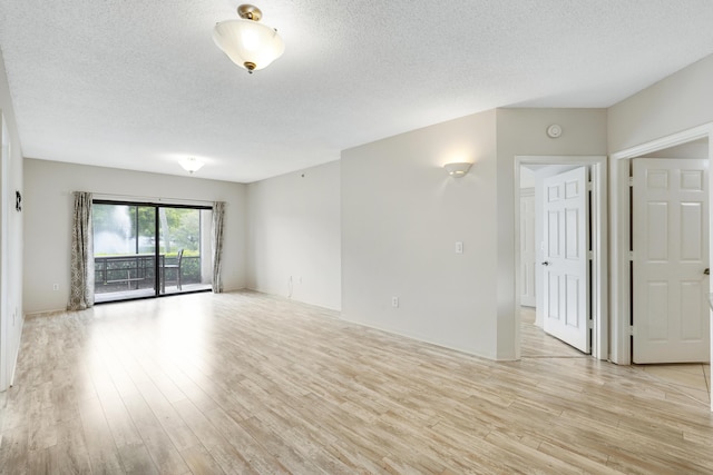 unfurnished room with a textured ceiling and light hardwood / wood-style flooring