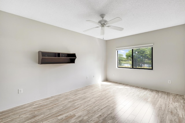 spare room with ceiling fan, light hardwood / wood-style flooring, and a textured ceiling