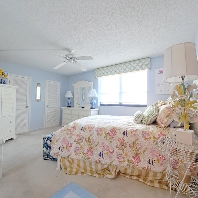 carpeted bedroom with ceiling fan and a textured ceiling