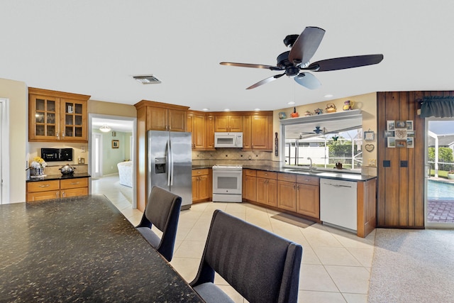 kitchen with backsplash, white appliances, ceiling fan, sink, and light tile floors