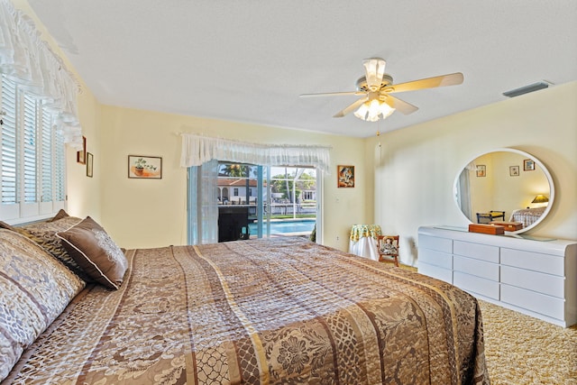 carpeted bedroom with a textured ceiling, ceiling fan, and access to outside