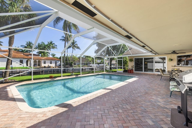 view of swimming pool featuring a patio area, ceiling fan, and glass enclosure