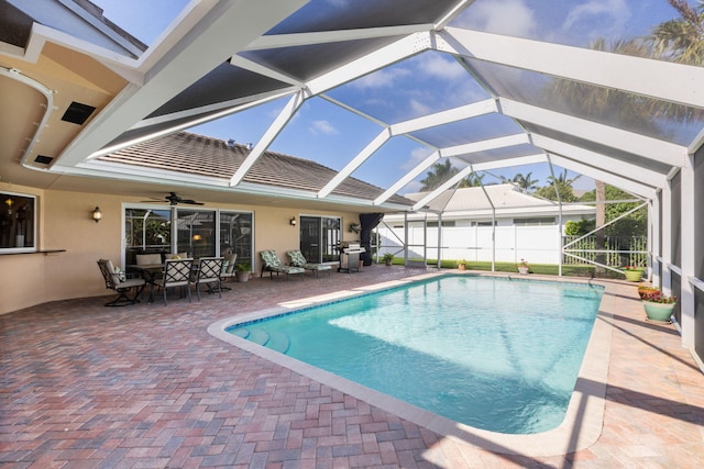 view of pool with a patio area, ceiling fan, and glass enclosure