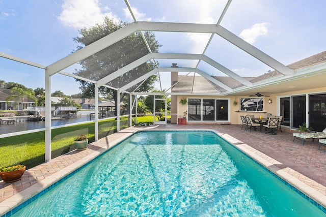 view of swimming pool with a lanai, a yard, ceiling fan, and a patio area