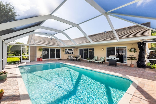 view of swimming pool with a patio area and glass enclosure