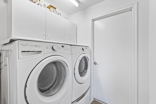 washroom featuring cabinets and washer and clothes dryer