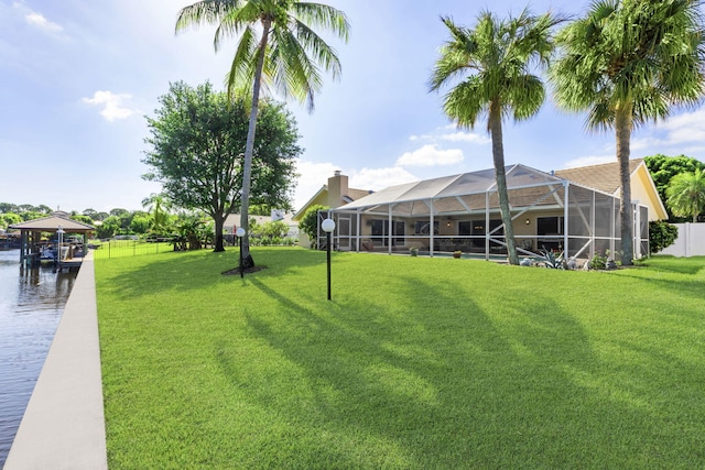 view of yard featuring a dock and glass enclosure