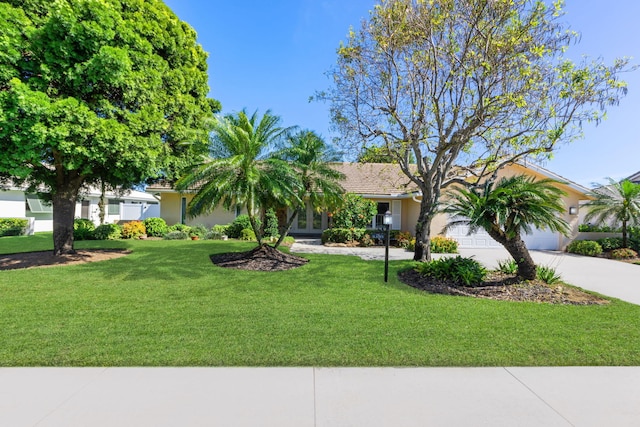 view of front of home with a garage and a front lawn