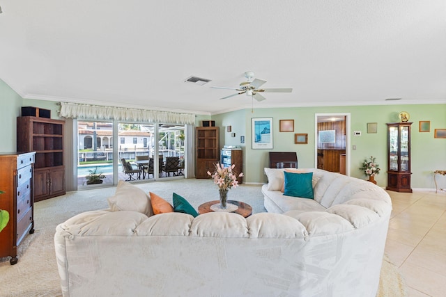 tiled living room with ornamental molding and ceiling fan