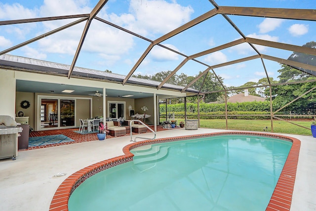 view of pool featuring glass enclosure, ceiling fan, and a patio area