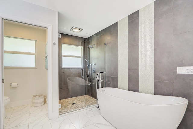 bathroom with tile walls, toilet, and separate shower and tub