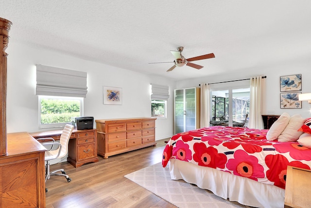 bedroom featuring multiple windows, access to exterior, light hardwood / wood-style flooring, and ceiling fan