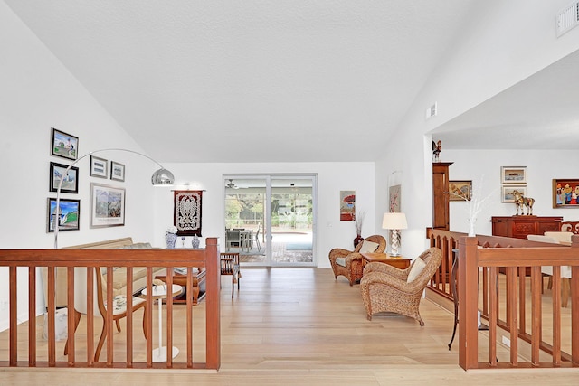 interior space with light hardwood / wood-style floors, a nursery area, and vaulted ceiling