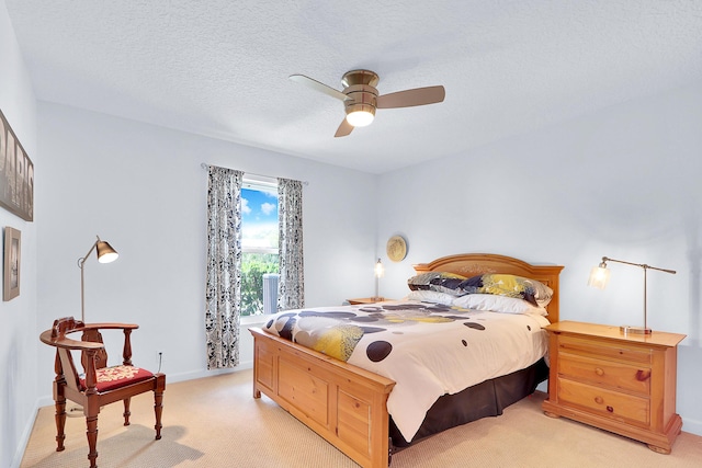 carpeted bedroom with ceiling fan and a textured ceiling