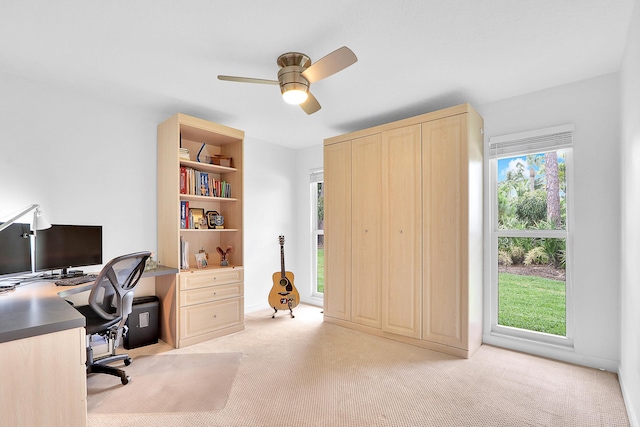 office area featuring light carpet, plenty of natural light, and ceiling fan