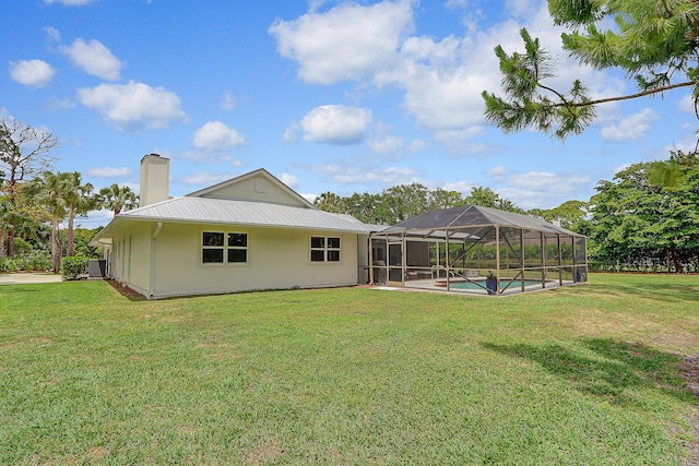 back of house featuring glass enclosure, a yard, and central air condition unit