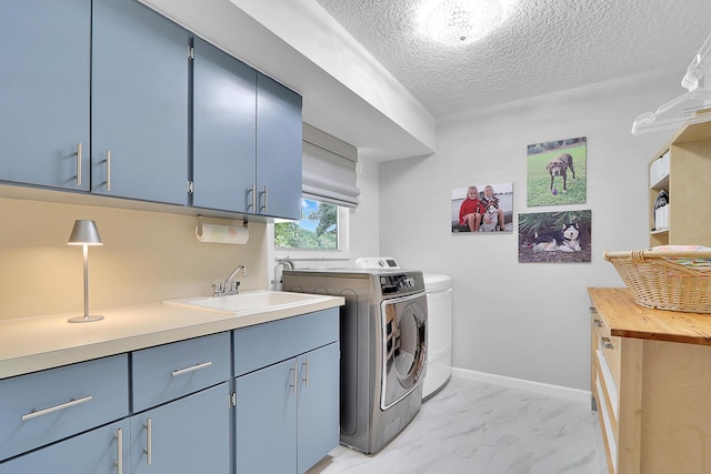 clothes washing area featuring sink, separate washer and dryer, cabinets, and a textured ceiling