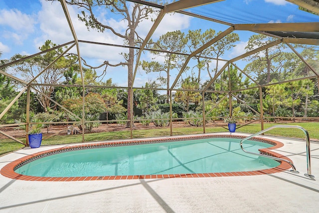 view of swimming pool featuring a lanai, a yard, and a patio