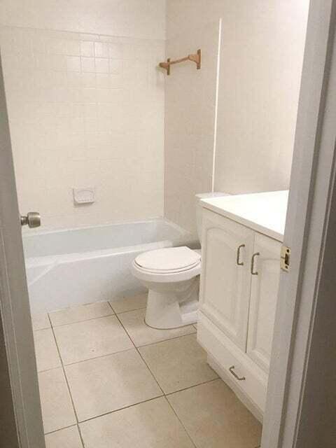 full bathroom featuring vanity, bathing tub / shower combination, toilet, and tile flooring