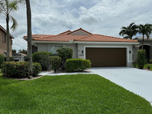 mediterranean / spanish-style house featuring a front yard and a garage