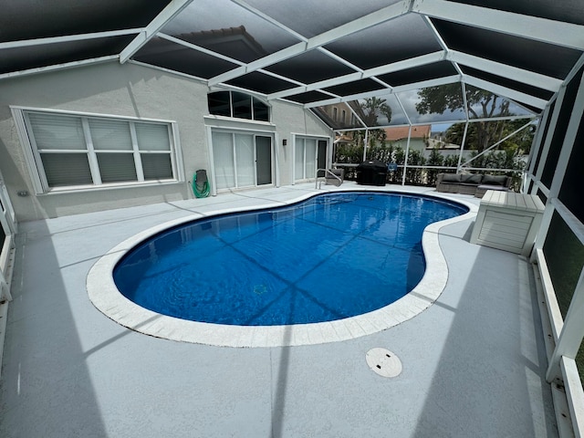 view of swimming pool with glass enclosure and a patio area