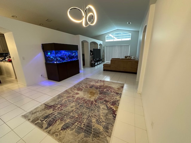 tiled living room with lofted ceiling and an inviting chandelier