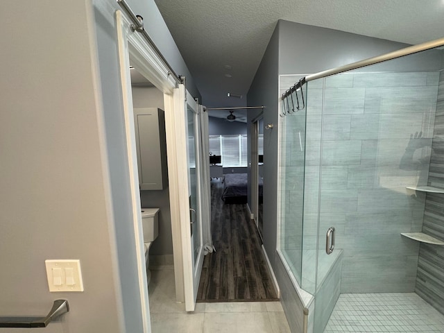 bathroom featuring hardwood / wood-style flooring, a textured ceiling, and an enclosed shower