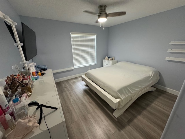 bedroom with hardwood / wood-style floors, a textured ceiling, and ceiling fan