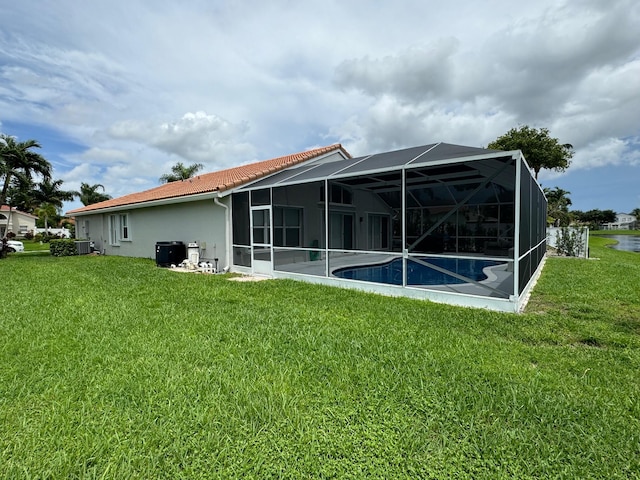 rear view of house featuring a lanai and a yard