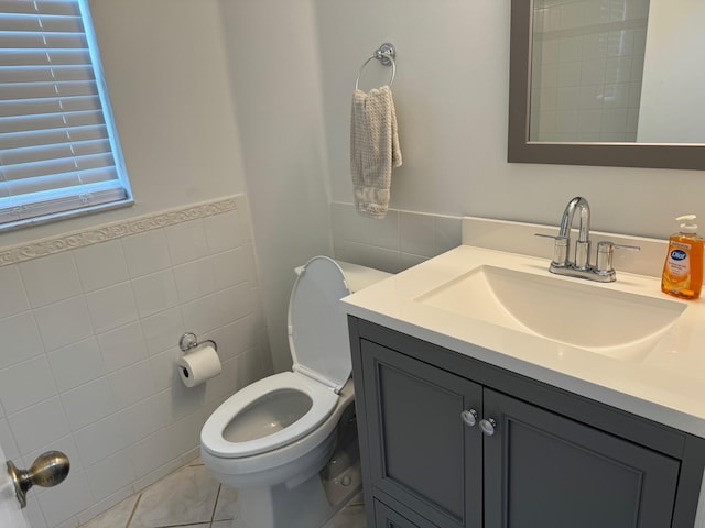 bathroom featuring tile patterned floors, tile walls, vanity, and toilet