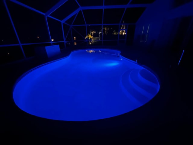 view of swimming pool featuring a lanai