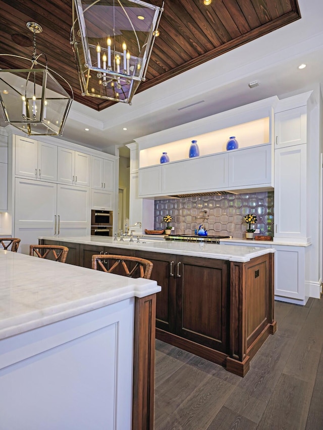 kitchen featuring wood ceiling, hanging light fixtures, white cabinets, and a tray ceiling